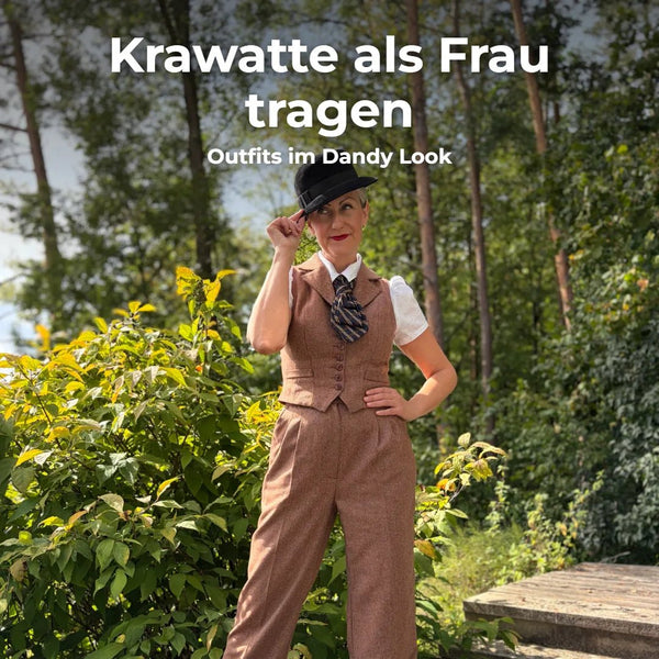 Frau im braunen Dandy Look mit Weste, Hose, Krawatte und Hut im Wald