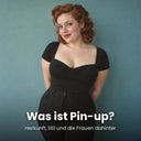 Rothaarige Frau mit Pin-up-Locken, rotem Lippenstift und schwarzem Oberteil mit Herzausschnitt vor einer petrolfarbenen Wand